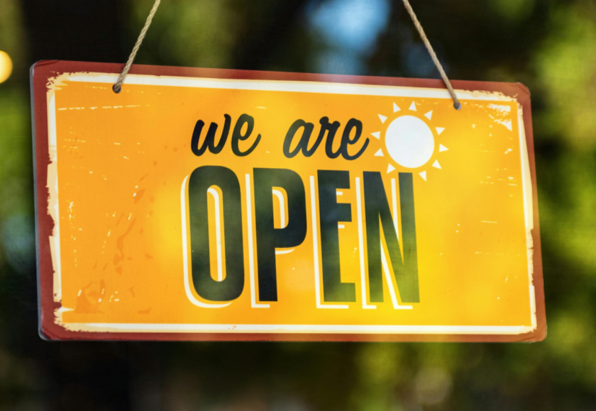 A Pet Shop Window sign in yellow with a sun symbol to represent Spring the the words we are open.